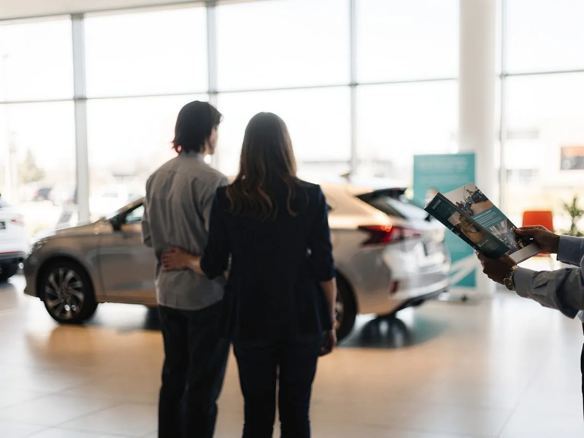 Pár si v autosalóne vyberá nové rodinné auto